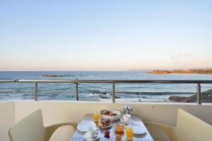 a table with drinks and a view of the ocean at Kalamaki Apartments in Kalamaki Chanion
