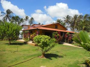 a house with palm trees in front of it at Pousada Temperança in Beberibe