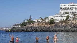 een groep mensen in het water op een strand bij Las Flores studio 4 in Playa de las Americas