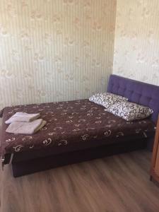 キーウにあるэконом метро Оболоньの紫のヘッドボード付きの客室の小さなベッド1台分です。