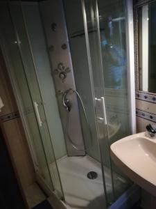 a shower with a glass door next to a sink at Casa Lausus in Lousã