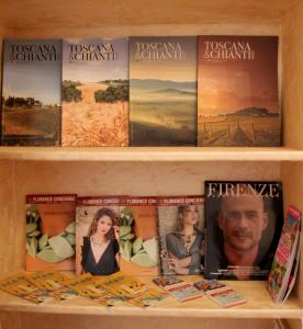 uma estante de livros com livros e revistas em My Ponte Vecchio apartment em Florença