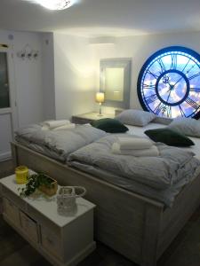 シビウにあるSonja's Nestのベッドルーム1室(大型ベッド1台、壁に大きな時計付)