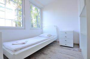 ソポトにあるVictus Apartamenty, Apartament La Figureの白いベッドルーム(ベッド1台、窓付)