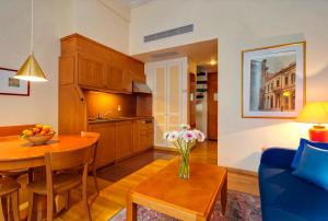 a kitchen and living room with a table and a blue couch at Hapimag Apartments Athens in Athens
