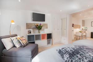 a living room with a couch and a tv on the wall at The Design Studio in Bath