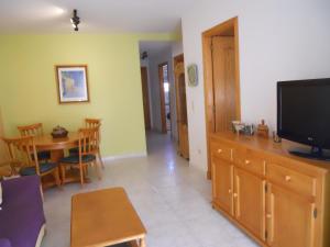 ein Wohnzimmer mit einem TV und einem Esszimmer in der Unterkunft Talima Las Marinas 1-Serviden in Denia