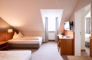 ハルベルクモースにあるHotel Alter Wirtのベッド2台とテレビがあるホテルの部屋