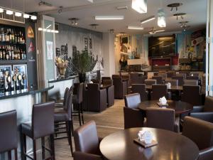 a restaurant with tables and chairs and a bar at Hotel Orchidee in Aalter