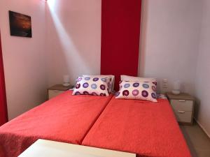 um quarto com uma cama vermelha e 2 almofadas em Mirtos Apartments em Myrtos