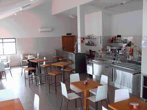 a restaurant with tables and chairs in a kitchen at Torreira Camping & Bungalows in Torreira