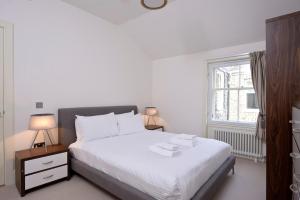 a bedroom with a bed and a dresser at Destiny Scotland - St Andrew Square Apartments in Edinburgh