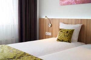 Postel nebo postele na pokoji v ubytování Amrâth Hotel Lapershoek Arenapark