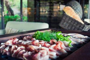 a tray of meat and vegetables on a table at Vallegrande Nature Resort by Geocharme in Cefalù