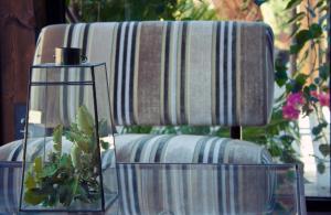 a couch with a table with a vase with a plant at Vallegrande Nature Resort by Geocharme in Cefalù