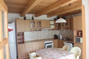 ヴェセリー・ナド・ルジニチーにあるHoliday House Krkavecのキッチン(木製キャビネット、テーブル、椅子付)