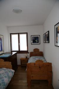1 dormitorio con 2 camas y 2 ventanas en Green Valley Altopiano di Pinè, en Montagnaga