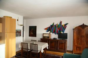 a dining room with a table and a tv at Green Valley Altopiano di Pinè in Montagnaga