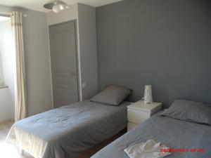 a bedroom with two beds and a lamp on a night stand at Gite du Mas duSuc in Bouxal