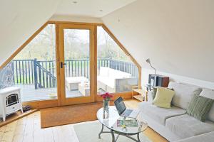 a living room with a couch and a glass table at Weavers Loft in Erpingham