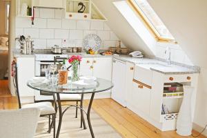 a kitchen with a glass table in a room at Weavers Loft in Erpingham