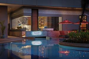 a hotel with a swimming pool in front of a restaurant at Amari Bangkok in Bangkok +37 photos