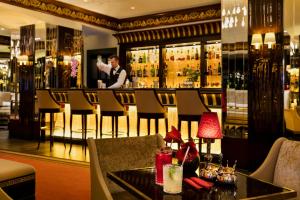 a restaurant with a bar with a man in the background at Hôtel Barrière Le Majestic Cannes in Cannes