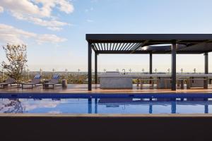 a swimming pool with chairs and a pavilion at Art Series - The Chen in Box Hill