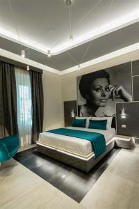 1 dormitorio con 1 cama y una pintura de una mujer en Via Veneto Luxury Suites, en Roma