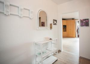 ein weißes Regal in einem Zimmer mit Spiegel in der Unterkunft Ferienwohnung Traumblick in Winterberg