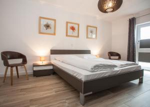 a bedroom with a bed and two chairs and a table at Fichtenweg 31-S in Winterberg