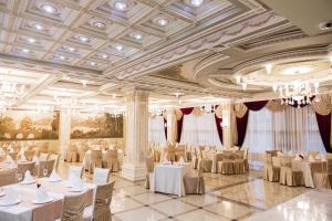 un salón de banquetes con mesas y sillas blancas en Hotel Imperator en Novosibirsk