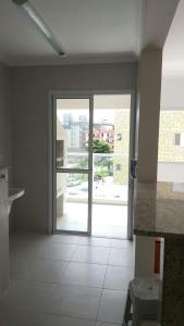 a kitchen with a large glass door to a patio at Apartamento Aconchegante in Ubatuba