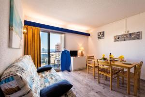 a living room with a table and a dining room at Lagrange Vacances Le Lydia Playa in Le Barcarès