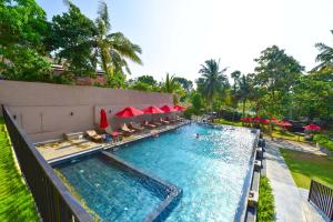 a swimming pool with chairs and umbrellas in a resort at Ballena Regency in Mirissa