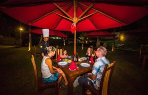 a group of people sitting at a table under an umbrella at Ballena Regency in Mirissa