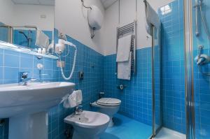 uma casa de banho em azulejos azuis com um lavatório e um WC em Villa Albina em Nápoles mais 37 fotografias