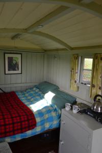 a small bedroom with a bed in a room at Shepherd's Hut in Blandford Forum