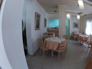 a dining room with a table and chairs and a kitchen at Hotel Orestion - Bike and motorcycle friendly hotel in Kastoria