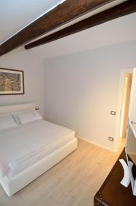 ein weißes Schlafzimmer mit einem Bett und einem Schreibtisch in der Unterkunft Blue Lagoon in Venedig