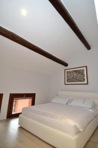 una camera bianca con un grande letto in mansarda di Blue Lagoon a Venezia