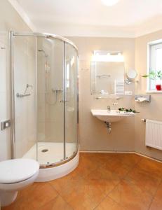 a bathroom with a shower and a toilet and a sink at Hotel Lafonte in Karlovy Vary