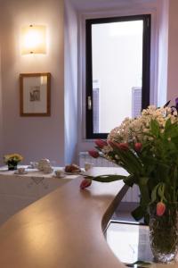 um vaso de flores sobre uma mesa na casa de banho em Campo Marzio Charming B&B em Roma