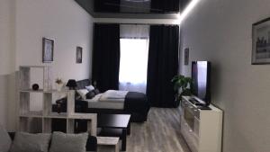 a living room with a bed and a room with a television at Am Brand in Mainz +13 photos