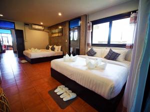 a hotel room with two beds and two windows at Pround Nan Cottage in Nan