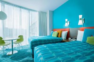 a hotel room with two beds and a table at Universal's Cabana Bay Beach Resort in Orlando +22 photos