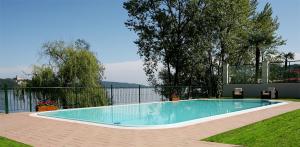 a swimming pool in a yard next to a fence at Residence Villa Greta in Meina