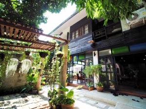Pround Nan Cottage في نان: ساحة مبنى به الكثير من النباتات