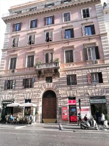 a large building on a city street with people sitting outside at Hotel Cortina in Rome