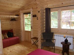 a living room with a red couch in a log cabin at Tumbleweed House in Aigrefeuille